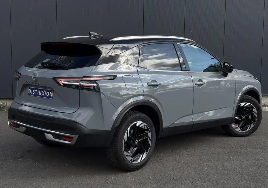 Nissan Qashqai 2025 gris Ceramic en 3/4 arrière droit avec toit noir et jantes alliage noires distinctives.