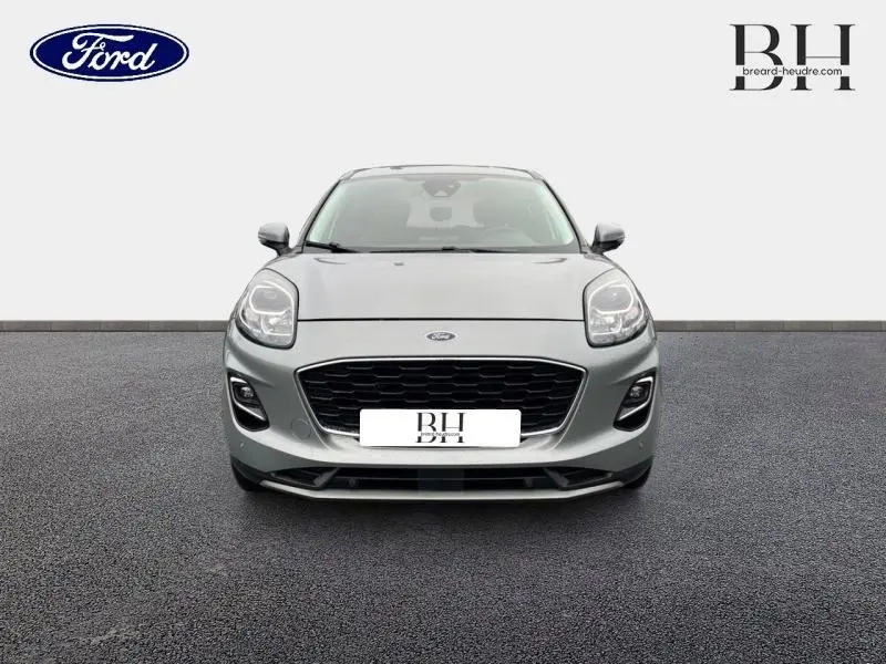 Vue frontale d'un Ford Puma gris Solar métallisé avec calandre noire et phares LED distinctifs.