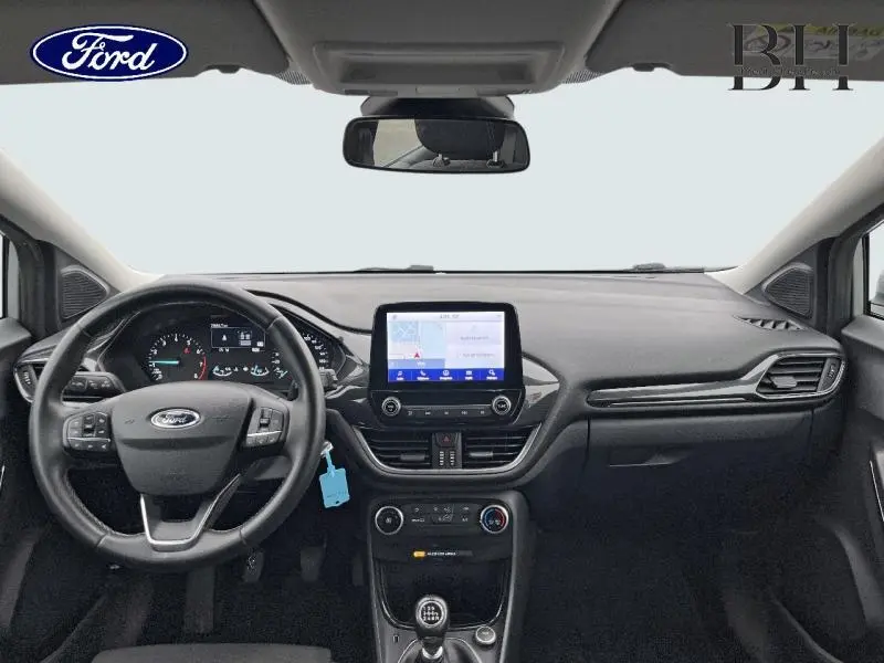 Vue intérieure avant du tableau de bord et volant multifonction du Ford Puma gris avec écran tactile central et boîte manuelle.