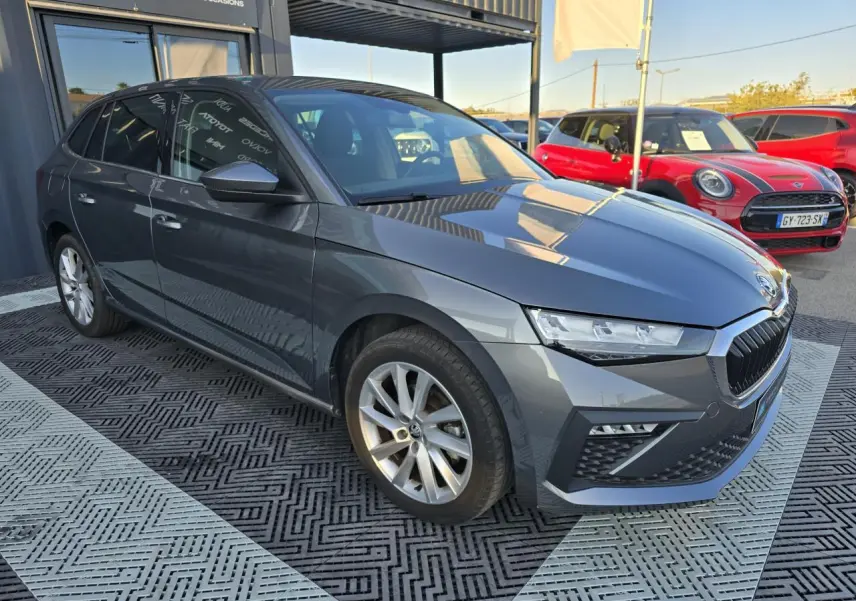 SKODA SCALA gris graphite métal vue 3/4 avant droit avec jantes alliage 17 pouces, stationnée en extérieur.
