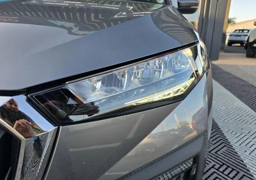 Gros plan sur le phare avant droit d’une Skoda Scala 2024 gris graphite métallisé avec calandre chromée.