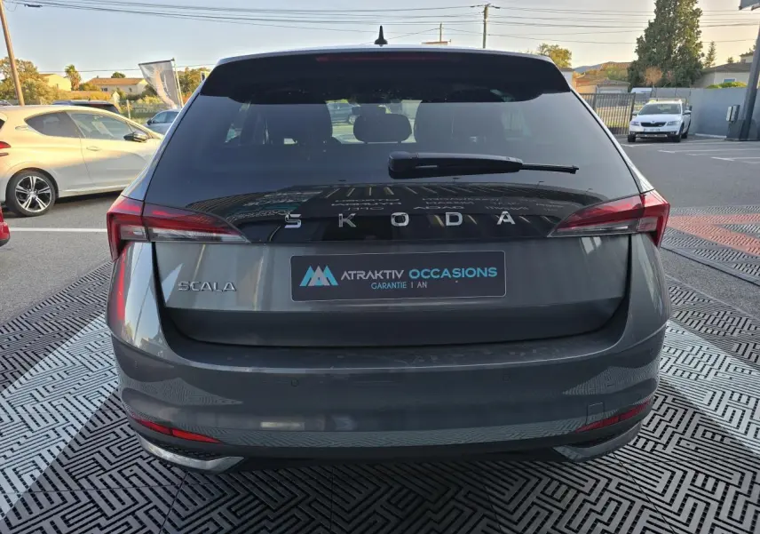 Vue arrière d'une Skoda Scala gris graphite métallisé avec feux arrière LED et logo SKODA visible.