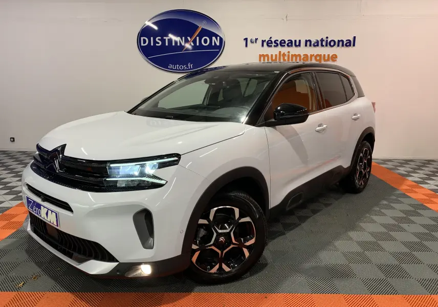 Citroën C5 Aircross Hybride blanc en 3/4 avant droit, avec toit noir et jantes bi-ton distinctives.