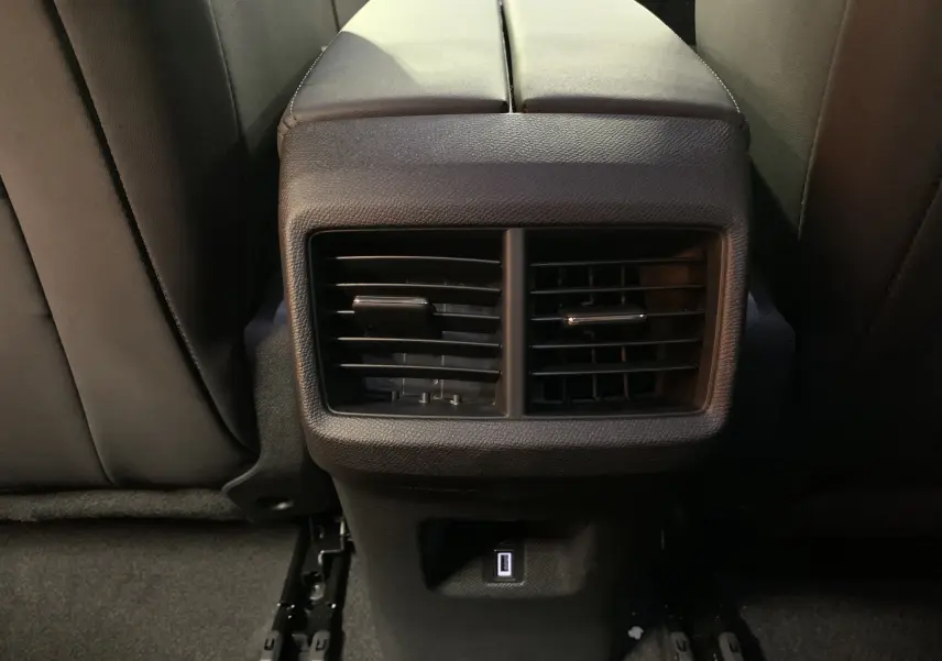 Coffre ouvert vu de l'arrière d'un Citroën C5 Aircross hybride blanc, espace de chargement propre et bien éclairé.