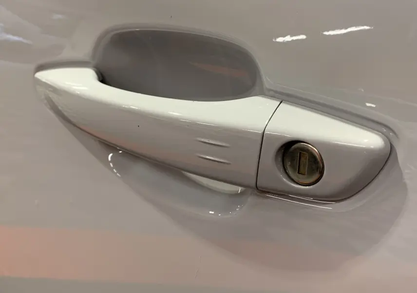 Poignée de porte blanche en gros plan sur le côté gauche d'une Citroën C5 Aircross hybride 2024.