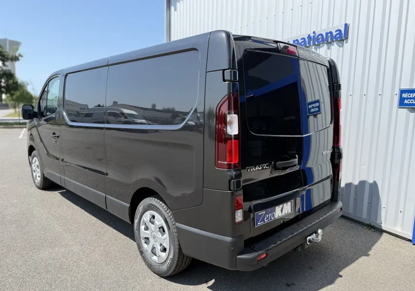 Renault Trafic Fourgon noir crépuscule métal vu en 3/4 arrière droit avec attelage et vitres teintées.