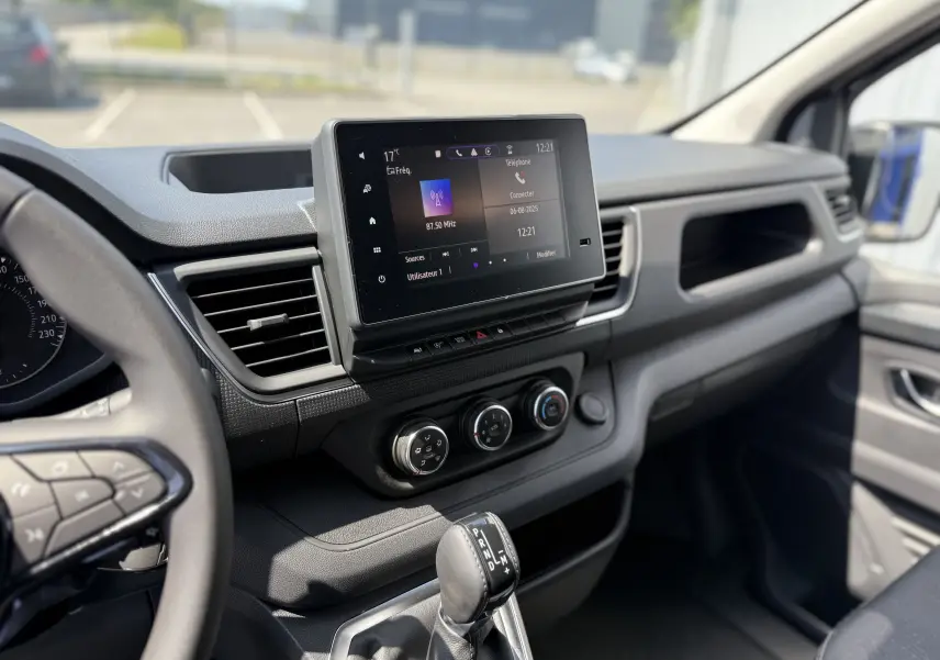 Intérieur du Renault Trafic Fourgon 2025, vue de la console centrale avec écran tactile et levier de vitesses automatique.