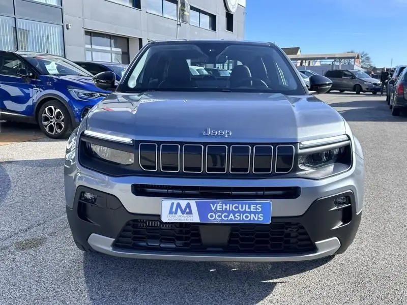 Vue avant d’un Jeep Avenger gris métallisé 2025 avec calandre noire distinctive et plaque « Véhicules Occasions ».
