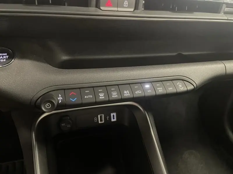 Vue rapprochée de la console centrale noire du Jeep Avenger 2025, montrant les commandes climatisation et ports USB.