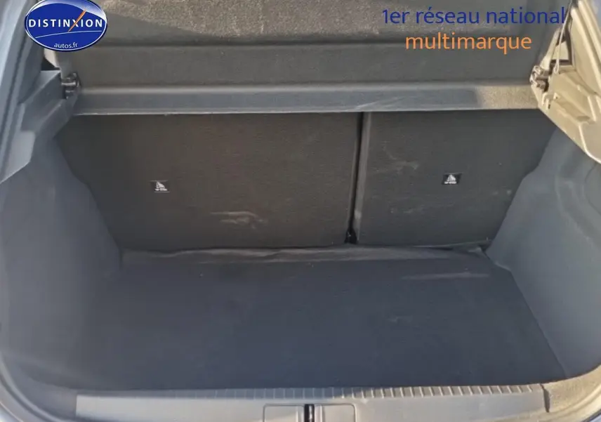 Coffre ouvert d’une Peugeot 208 gris artense, montrant l’espace de chargement arrière vide.