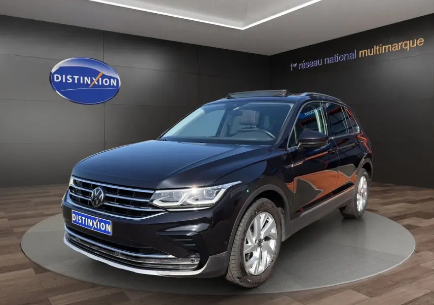 Volkswagen Tiguan noir intense en 3/4 avant droit, jantes alu 18 pouces et toit panoramique visible.
