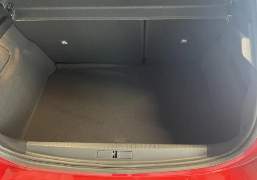 Coffre ouvert vu de face d’une Opel Corsa rouge 2026, intérieur noir et seuil de coffre gris.