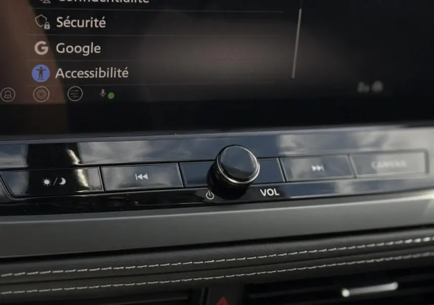 Gros plan sur la molette de volume et les commandes multimédia du tableau de bord du Nissan Qashqai gris Ceramic 2025