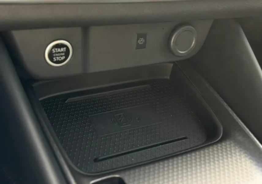 Détail du chargeur à induction et bouton Start/Stop dans l'habitacle du Nissan Qashqai III gris Ceramic 2025.