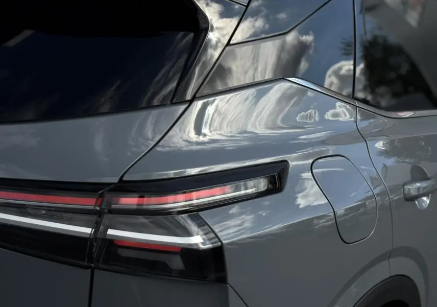 Gros plan sur l'arrière droit du Nissan Qashqai gris Ceramic, mettant en valeur le feu arrière LED et la trappe à carburant.