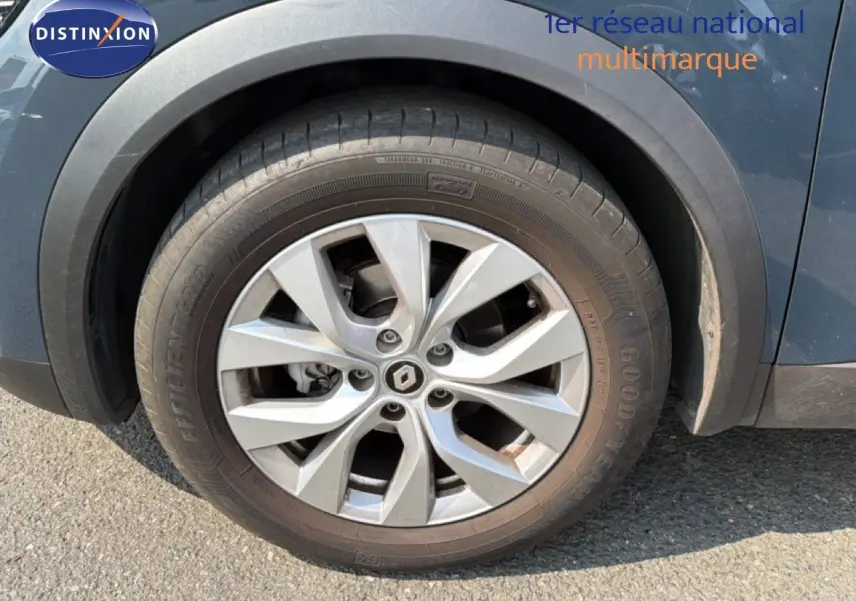 Gros plan sur la roue avant gauche d’un Renault Captur bleu marine fumé avec jante alliage à plusieurs branches.