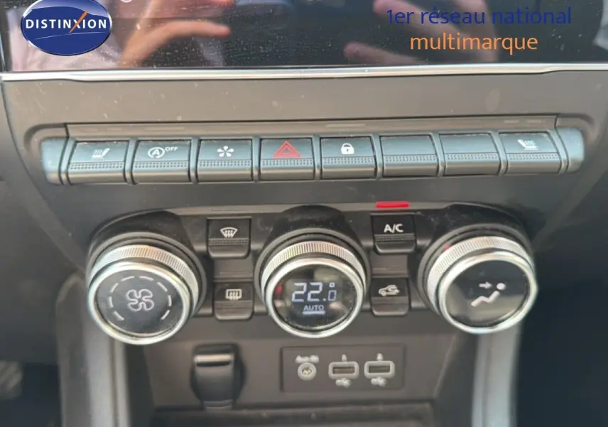 Gros plan sur la console centrale du Renault Captur 2022, montrant les commandes de climatisation et les boutons fonctionnels.