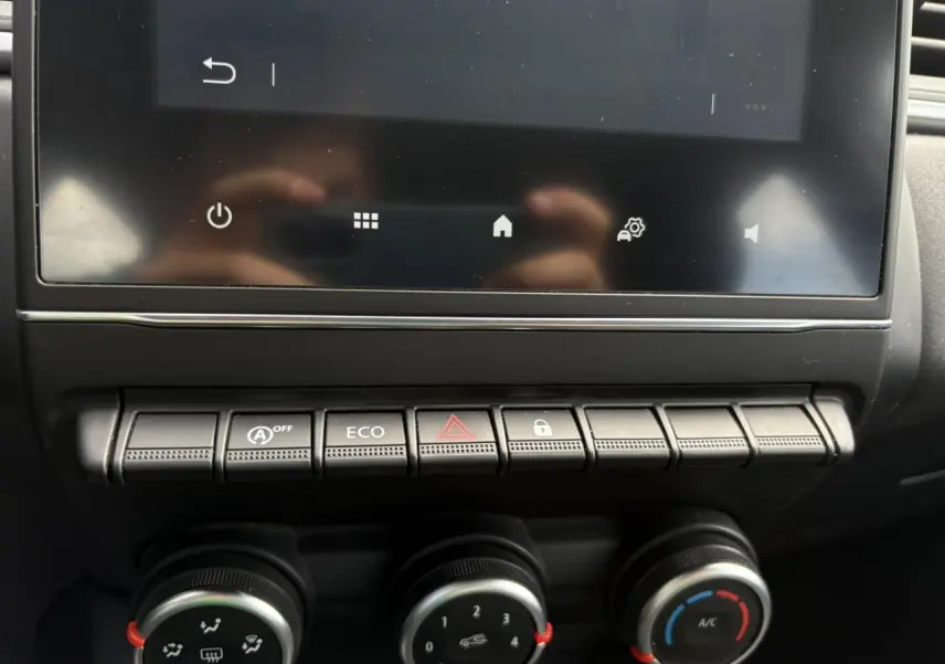 Gros plan sur la console centrale du Renault Captur blanc nacré 2022, avec commandes climatisation et mode Eco visibles.