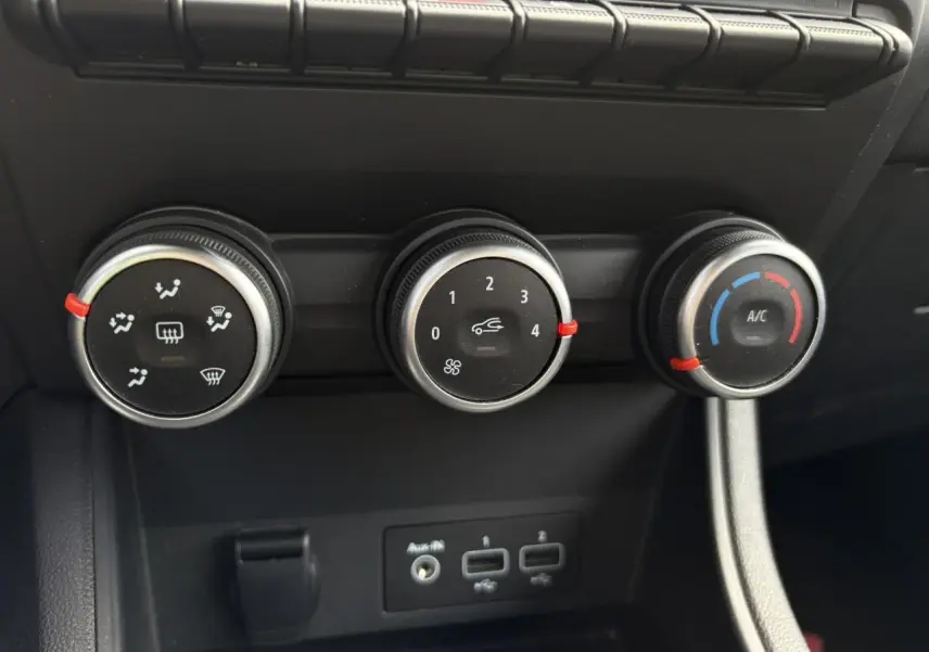Commandes manuelles de climatisation avec trois molettes noires et prises USB sur la console centrale du Renault Captur blanc nacré 2022.