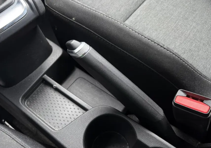 Gros plan sur le frein à main manuel et la console centrale noire du Renault Captur TCE 90 Business 2022.
