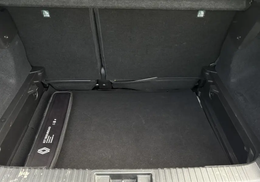 Coffre ouvert du Renault Captur blanc nacré 2022, vue intérieure montrant un rangement sécurisé et tapis noir.