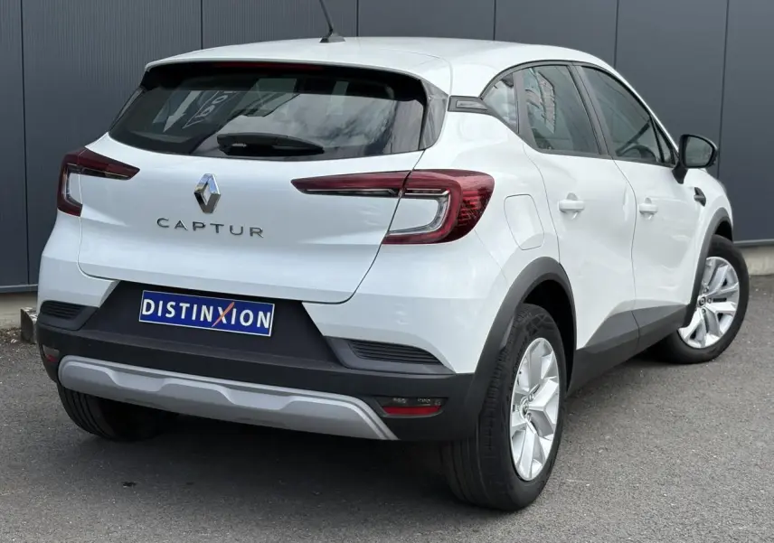 Vue 3/4 arrière droite d'un Renault Captur blanc nacré 2022 avec feux arrière LED et plaque Distinxion.