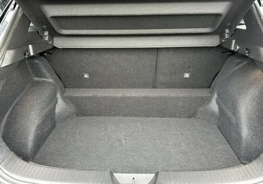 Coffre spacieux et vide du Nissan Qashqai III noir nacré, vue intérieure arrière avec habillage gris foncé.