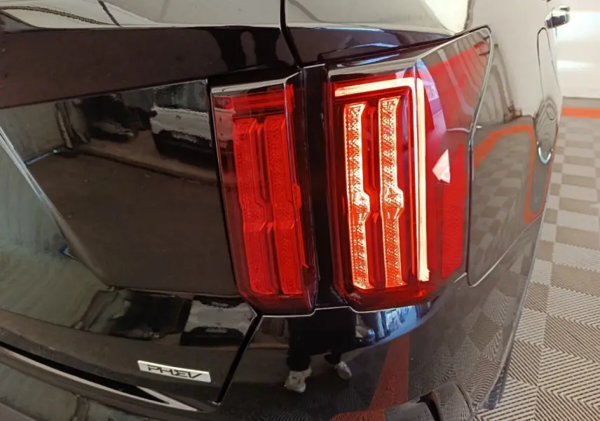Gros plan sur le feu arrière droit rouge du KIA Sorento noir hybride rechargeable avec badge PHEV visible.