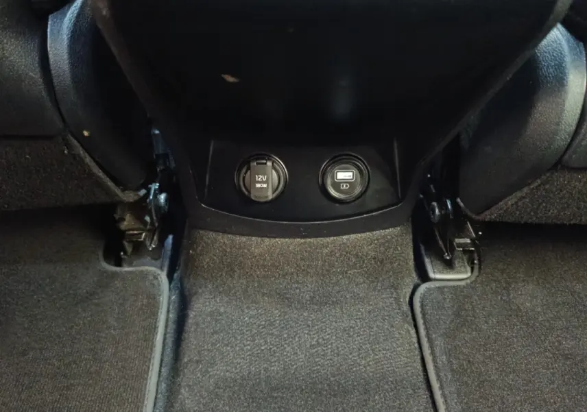 Prise 12V et port USB intégrés au bas de la console centrale, intérieur noir du Kia Sorento 2023 hybride rechargeable.