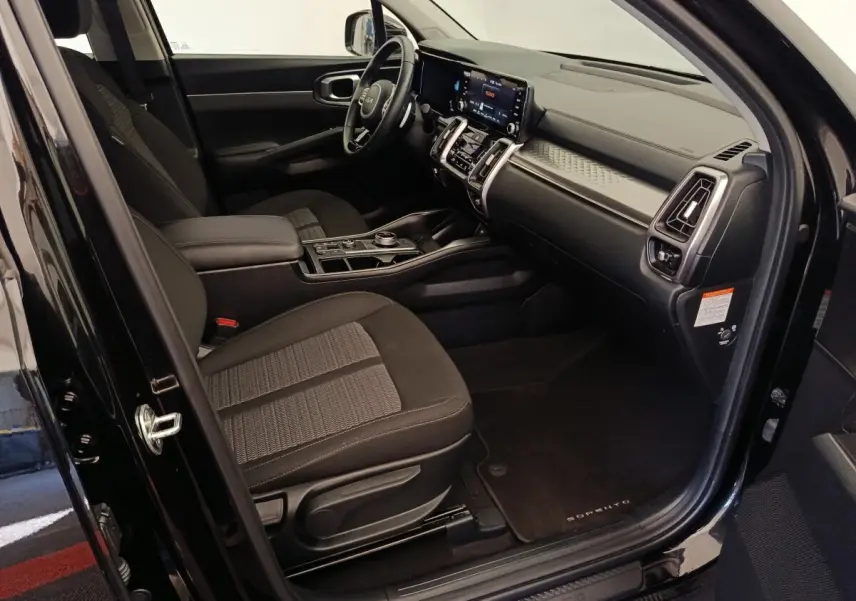 Intérieur côté conducteur du KIA Sorento noir 2023, avec tableau de bord moderne et écran tactile central.