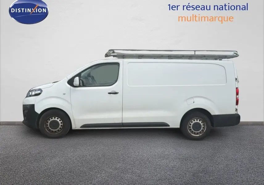 Vue latérale droite d’un utilitaire Citroën Jumpy XL blanc avec galerie de toit métallique.