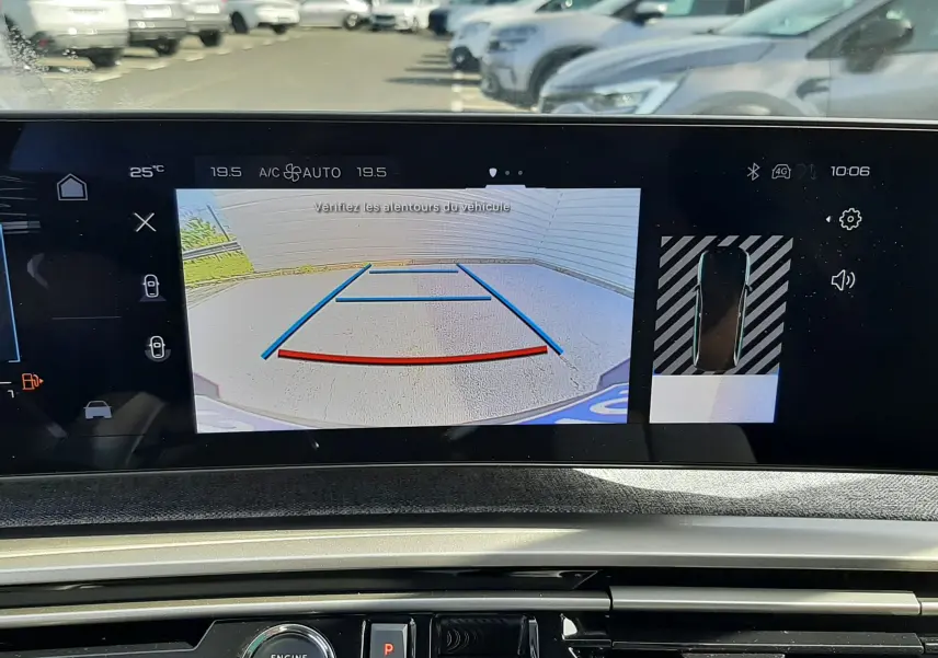 Vue intérieure du tableau de bord du Peugeot 5008 Hybrid 2025 avec écran de caméra de recul et commandes de boîte automatique.