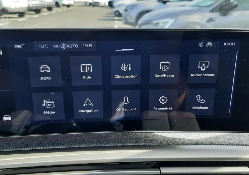 Vue rapprochée de l’écran tactile central et de la console d’une Peugeot 5008 gris Artense, affichant les options de climatisation et navigation.