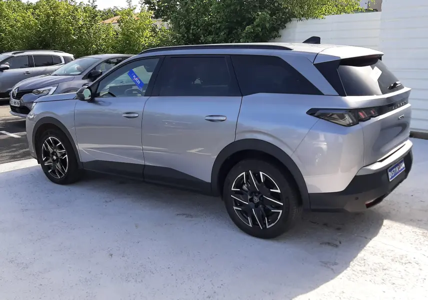 Peugeot 5008 Hybrid gris Artense métal en vue 3/4 arrière droit, avec toit noir et jantes alliage noires.