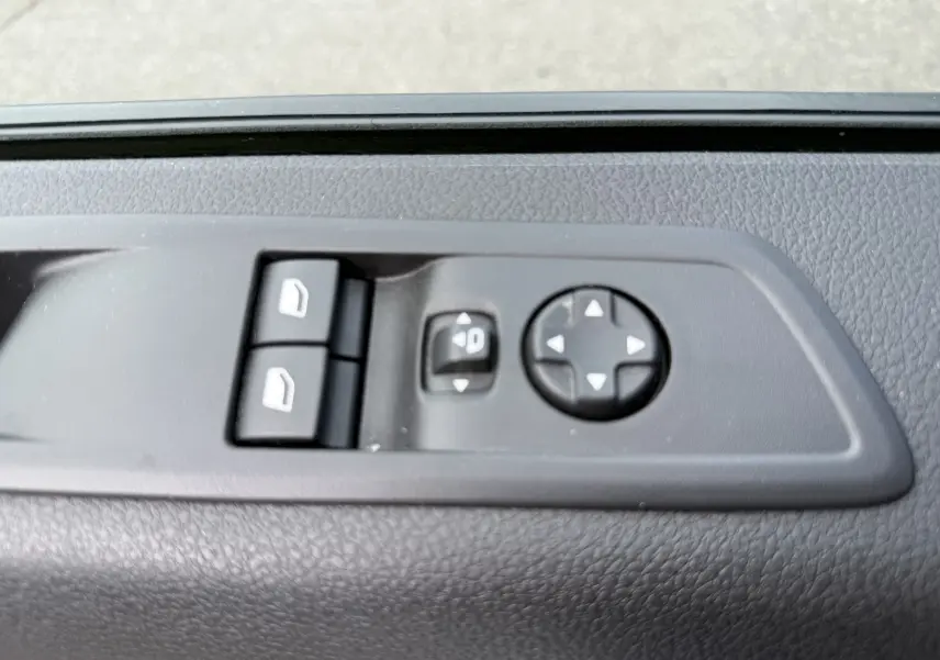 Gros plan sur les commandes de réglage des vitres et des rétroviseurs côté conducteur du FIAT Scudo Fourgon blanc Icy 2025.