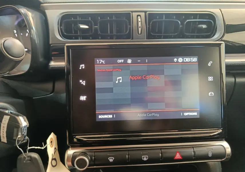 Vue rapprochée du tableau de bord de la Citroën C3 2024 gris foncé, avec écran tactile affichant Apple CarPlay.