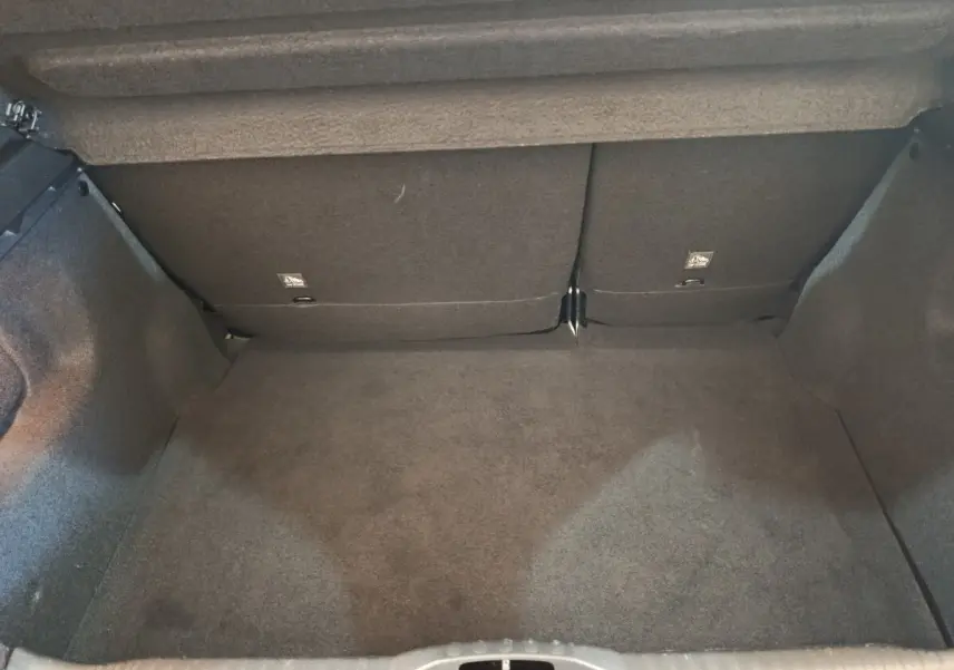 Coffre vide vu de face d'une Citroën C3 gris foncé, montrant la banquette arrière rabattable et le revêtement intérieur.