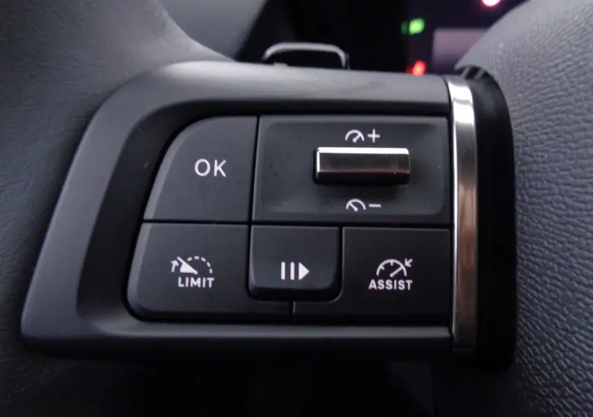 Gros plan sur les commandes au volant gauche du Citroën C5 X noir métal, avec boutons de limitation et assistance de vitesse.