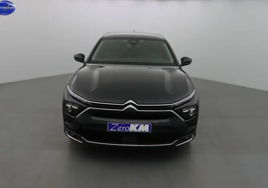 Vue frontale d'une Citroën C5 X noire métal avec signature lumineuse LED et calandre chromée distinctive.