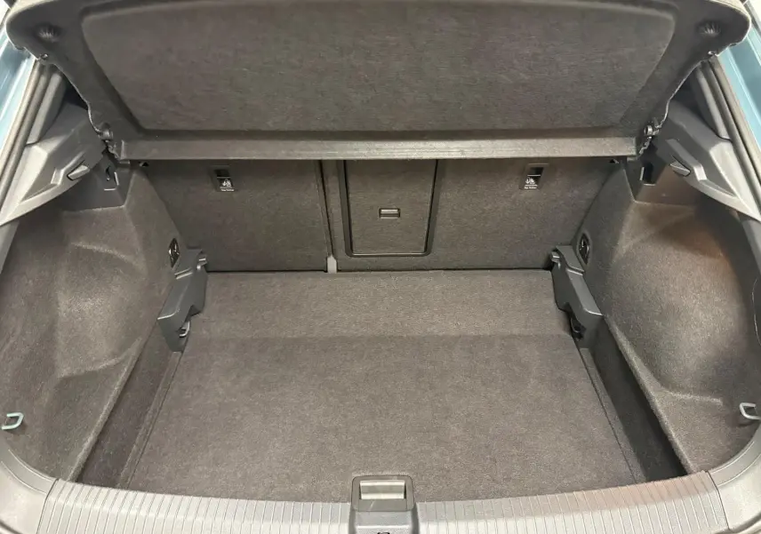 Coffre ouvert du Volkswagen T-Roc 2024, vue intérieure, montrant un espace de chargement propre et bien agencé.