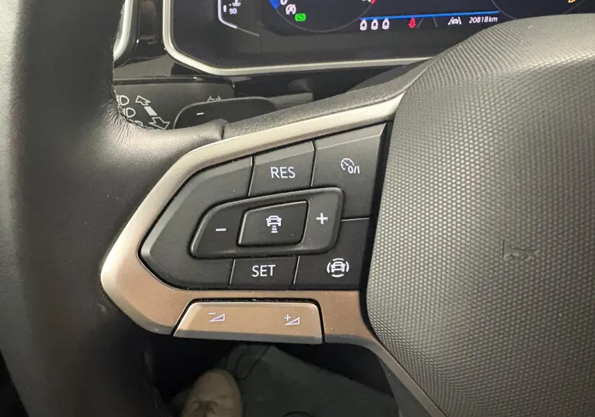 Gros plan sur les commandes au volant du Volkswagen T-Roc 2024, version R-Line, avec tableau de bord numérique visible.