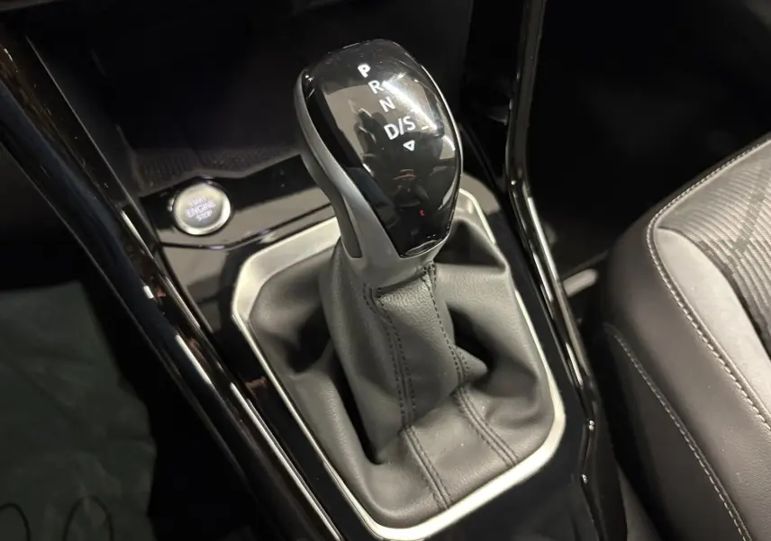 Le levier de vitesse automatique du Volkswagen T-Roc 2024 R-Line, entouré de cuir noir et bouton start/stop visible.