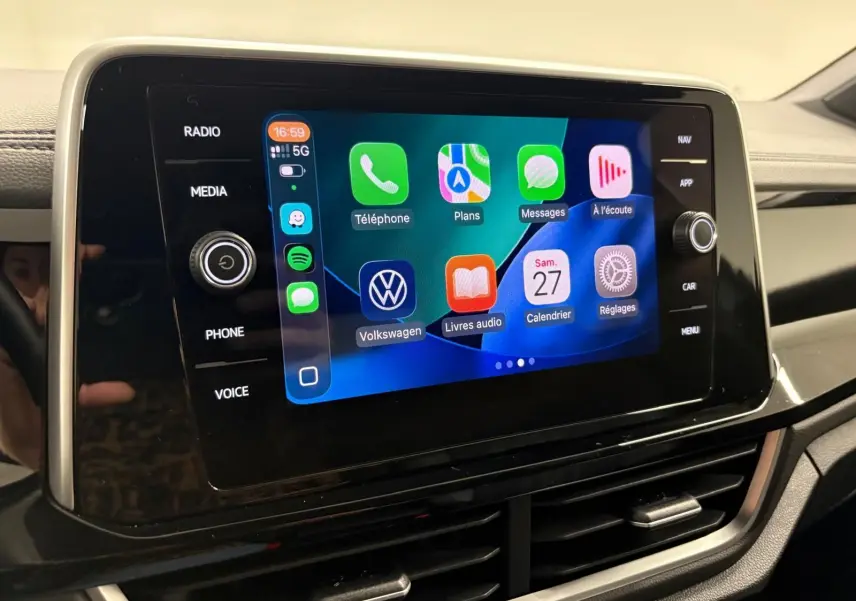 Écran tactile central du Volkswagen T-Roc 2024 affichant l'interface Apple CarPlay avec commandes autour.