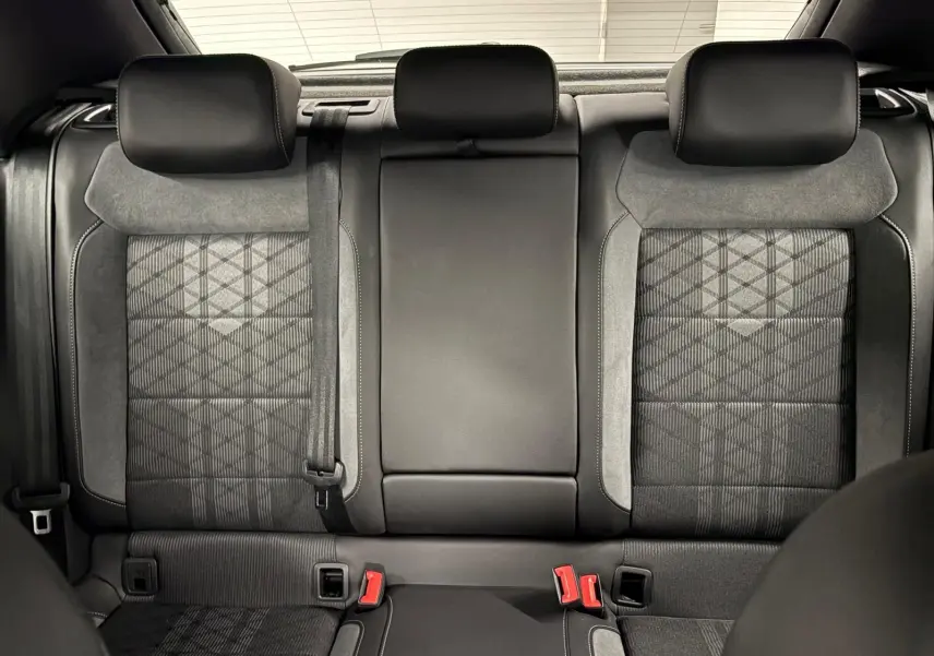 Vue intérieure sur les sièges arrière du Volkswagen T-Roc 2024, finition R-Line, avec sellerie noire et gris anthracite.