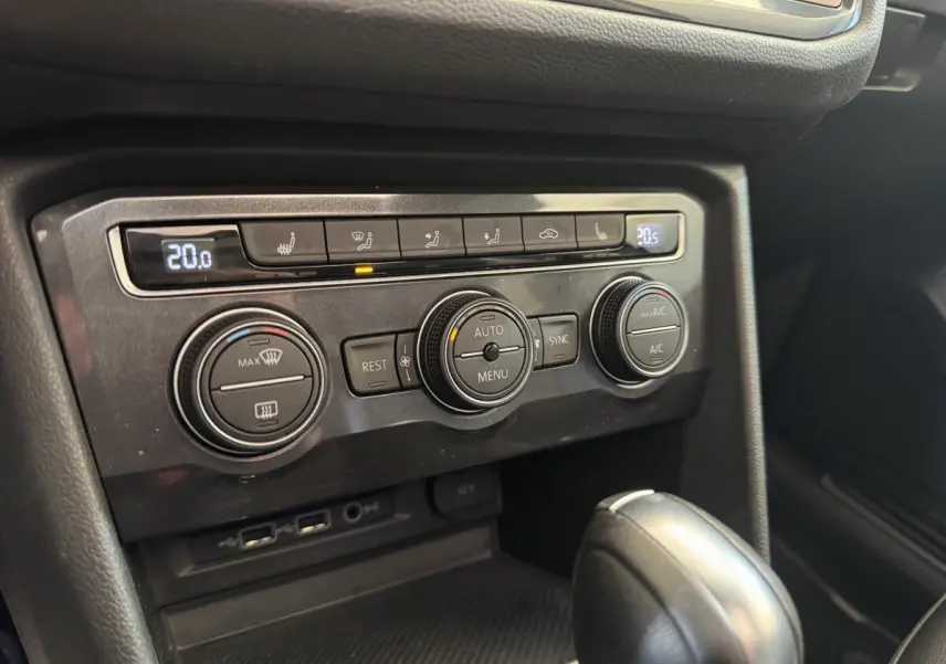 Gros plan sur la console centrale noire du Volkswagen Tiguan Allspace 2019, montrant les commandes de climatisation et la boîte auto.