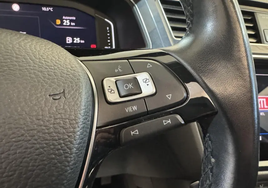 Gros plan sur le volant cuir noir du Volkswagen Tiguan Allspace 2019, avec commandes multifonctions et affichage digital visible.