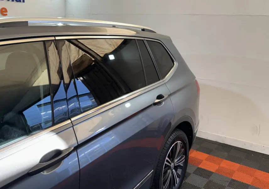 Vue latérale côté droit d'un Volkswagen Tiguan Allspace gris foncé avec jantes alliage et vitres teintées.