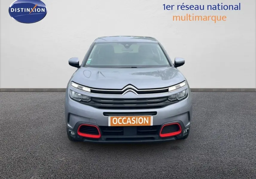 Vue avant d'un Citroën C5 Aircross gris clair métal avec détails rouges sur le pare-chocs et calandre distinctive.