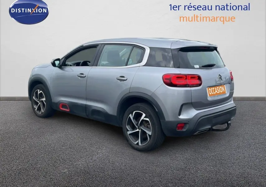 Vue 3/4 arrière droite d'un Citroën C5 Aircross gris clair métal avec feux arrière LED et jantes alliage.