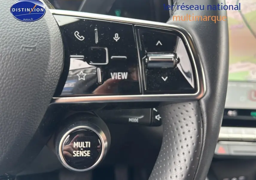Gros plan sur le volant cuir perforé du Renault Austral gris schiste, avec commandes multifonctions et bouton Multi Sense.